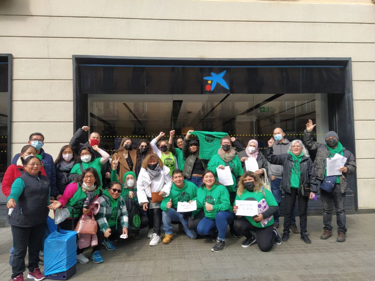 Un grupo de activistas de la PAHposa delante de las puertas de una entidad bancaria en Barcelona.